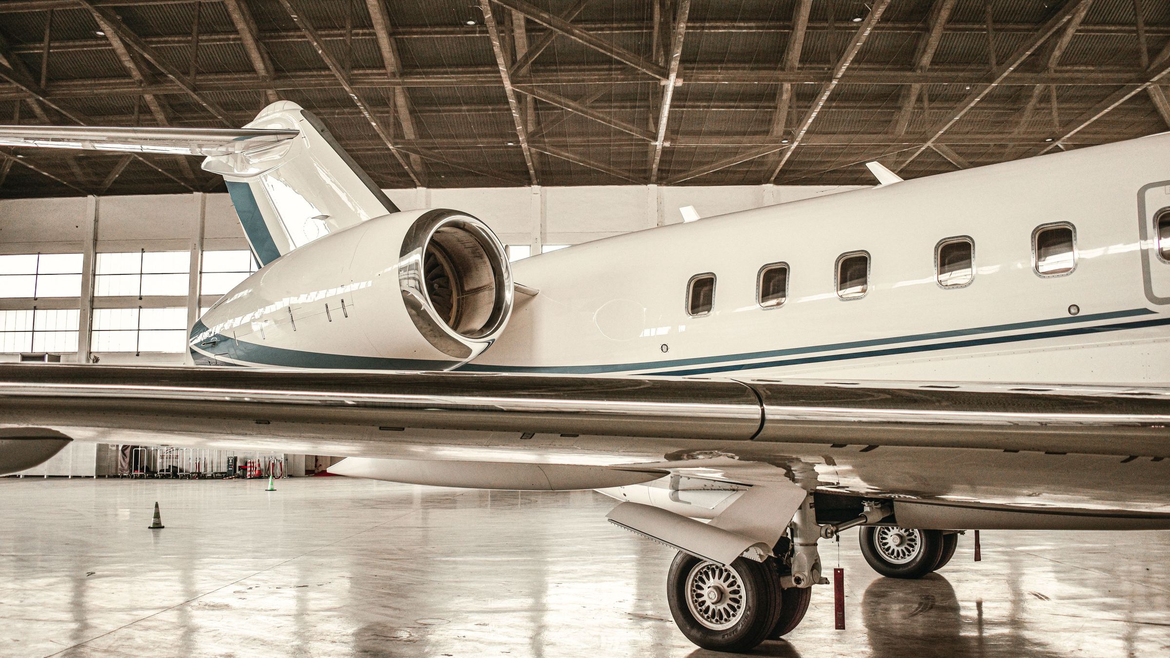 The fuselage and engine of a business jet in a hangar.