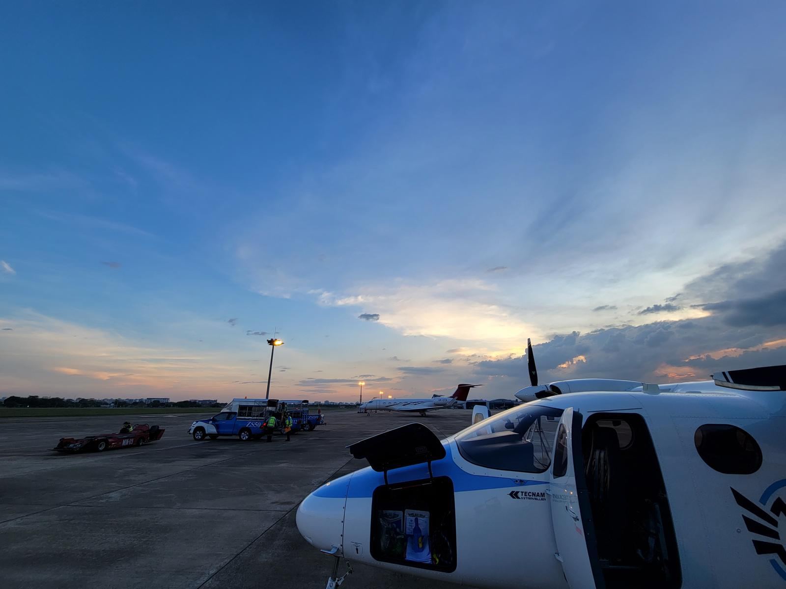 A Tecnam Traveller at dusk with its nose baggage hatch open and bags inside.