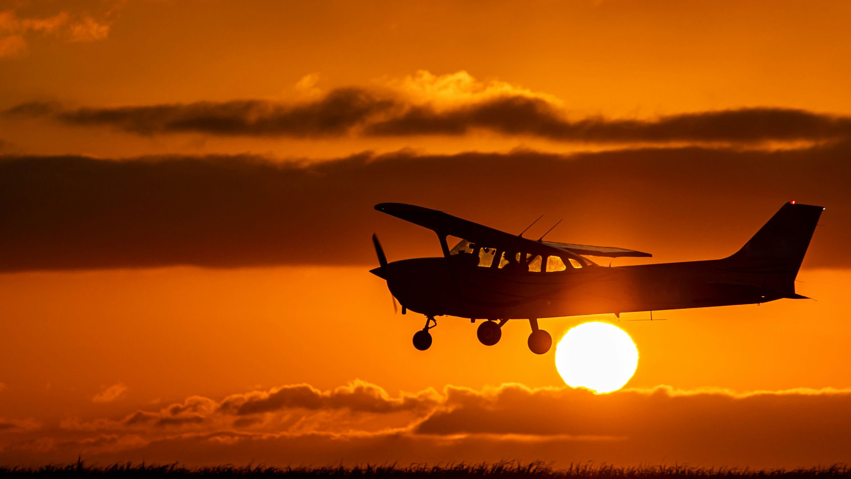 A Cessna 172 silhouetted against a sunset sky. Stock photograph.