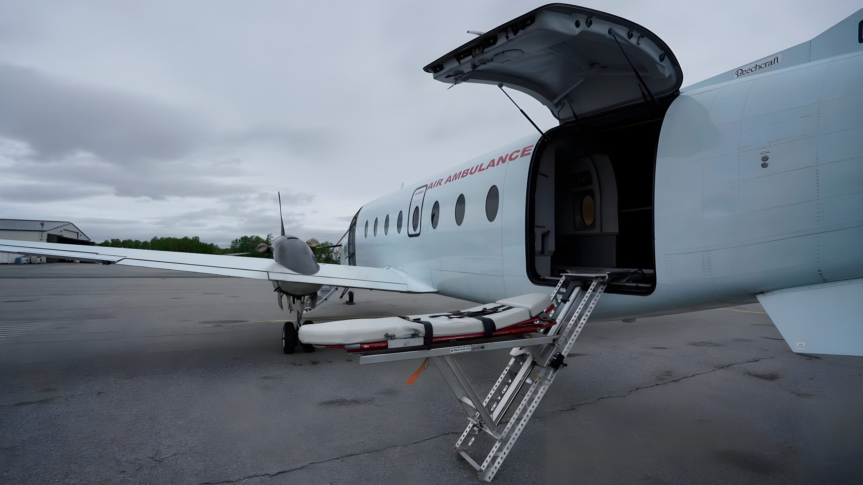 A Beechcraft 1900D air ambulance with its rear cargo door open and a stretcher on the loading ramp